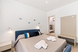 a bedroom with a bed with towels on it at La Pulvarera in Castelsardo