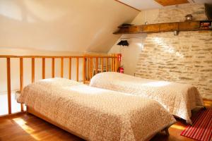 two beds in a room with a stone wall at Tôlluste Villa in Tõlluste