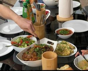 a table full of plates of food with a person eating at Hotel AnOrita in Kobuleti