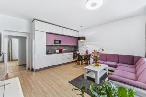 a living room with a purple couch and a table at Walter&Sons Apartment Centro in Poděbrady