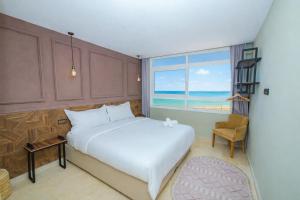 a bedroom with a bed and a window with the ocean at Singular Hotel, SH Dakhla in Dakhla