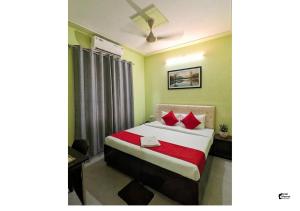 a bedroom with a bed with red pillows at Hotel HMI International in Meerut