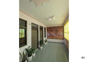 a hallway with potted plants in a building at Hotel HMI International in Meerut