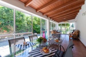 a dining room with a table and chairs and windows at Monte das Palmeiras by Algarve Holidays in Loulé