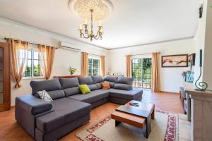 a living room with a couch and a table at Monte das Palmeiras by Algarve Holidays in Loulé