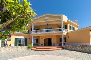 a large yellow house with a balcony at Monte das Palmeiras by Algarve Holidays in Loulé