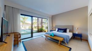 a bedroom with a bed and a large window at Mythic Suites & Villas by MJ Holidays in Grande Gaube +106 photos