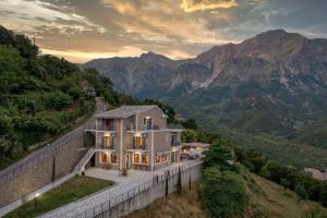 a house on a hill with mountains in the background at Lithorama Granitsa mountain rooms in Granitsa