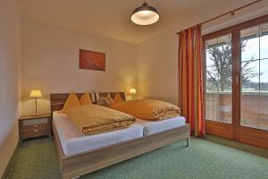 a bedroom with a bed with orange pillows and a window at Stiedlbauerhof in Seeham