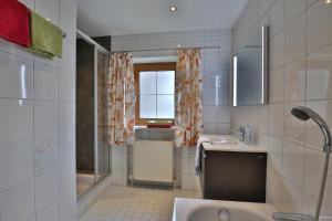 a bathroom with a sink and a tub and a window at Stiedlbauerhof in Seeham +56 photos
