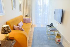 a living room with a yellow couch and a tv at TM Luxury Apartments Lisbon in Lisbon