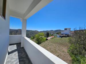 a view from the balcony of a house at Lushtree Backpackers - Hostel & Cafe in Mukteshwar