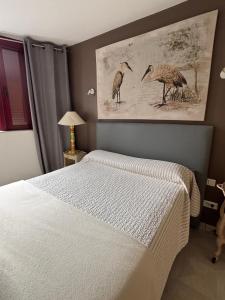 a bedroom with a bed with two birds on the wall at L'Abribis in Firminy +55 photos