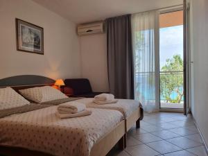 a hotel room with two beds with towels on them at Tourist Settlement Brzet in Omiš