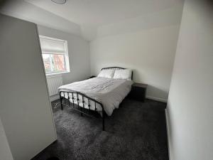 ein Schlafzimmer mit einem Bett in einem weißen Zimmer in der Unterkunft SAMAz in Manchester