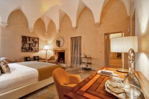 a bedroom with a bed and a desk with a table at Palazzo Maresgallo Suites & SPA in Lecce +83 photos