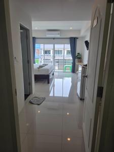 a white room with a bed and a view of a building at Near the Beach Cha-Am in Cha Am