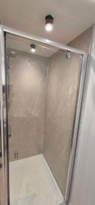 a shower with a glass door in a bathroom at Wayside Cottage Gairloch Room Accommodation in Gairloch