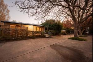 a house with a tree in front of it at Minffordd Cottage in Feilding