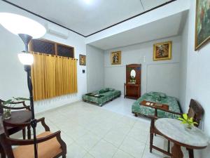 a living room with a bed and a table and chairs at Ghanaya Guesthouse in Ngaglik
