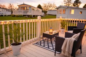 a deck with chairs and a table on a fence at Rosie's Seton Retreat in Port Seton