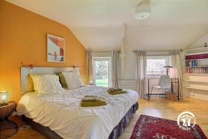 a bedroom with a large bed with white sheets at Fenêtres sur le golfe in Sarzeau +48 photos
