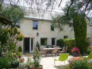 a house with a patio with a table and chairs at Fenêtres sur le golfe in Sarzeau