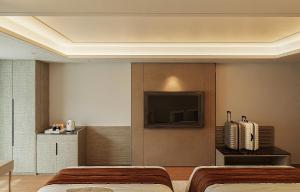a bedroom with two beds and a flat screen tv at Splendid Star Suite Hotel in Hanoi