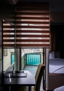 a room with a desk and a bed and a window at Sobe i Apartmani Vila Modex in Paraćin