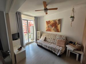 a living room with a couch and a ceiling fan at Apartamento en Mar Blau Calella in Calella
