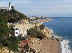 a lighthouse on top of a cliff next to the ocean at Apartamento en Mar Blau Calella in Calella