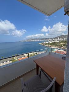 a balcony with a table and a view of the ocean at Redi's Seaview Apartments in Sarandë