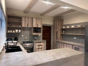 a kitchen with wooden cabinets and a counter top at Imbarudo Residence in Victoria Falls