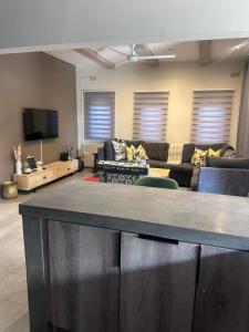 a living room with a couch and a tv at Imbarudo Residence in Victoria Falls
