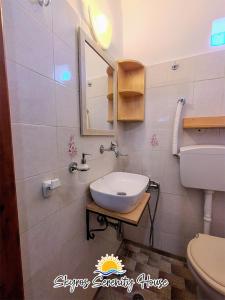 a bathroom with a sink and a toilet and a mirror at Skyros Serenity House in Skiros