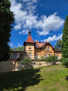 a house with a tower on top of a yard at Tavba apartment in Česká Lípa