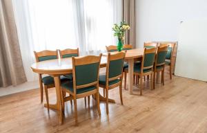 a dining room table with chairs and a vase of flowers at Tavba apartment in Česká Lípa +20 photos