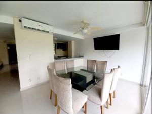 a dining room with a glass table and chairs at Suite Club Deportivo in Acapulco
