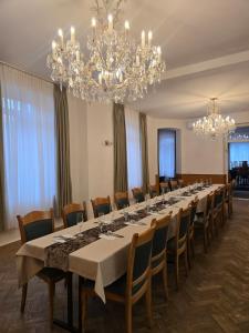 a large dining room with a long table and chandeliers at Tavba apartment in Česká Lípa