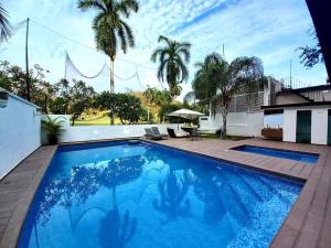 a large blue swimming pool with a patio and a table at Suite Club Deportivo in Acapulco