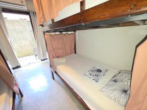 an empty bunk bed in a room with a window at jbsurf House in Catagnan