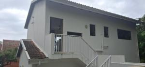 a white house with white stairs and a building at Villa Ti Amo Flat in Ramsgate