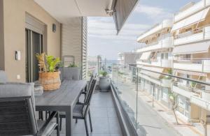 a balcony with a wooden table and chairs on a building at White Haven in Korinthos
