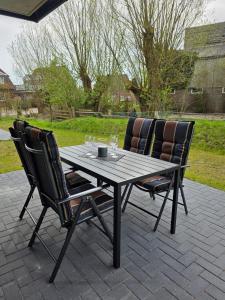 a table and two chairs with wine glasses on a patio at Ferienwohnung Möwentöne in Bensersiel