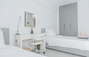 a bedroom with two beds and a desk and a chair at White Haven in Korinthos