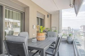 a wooden table and chairs on a patio with a window at White Haven in Korinthos
