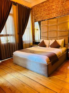 a bedroom with a large bed with a brick wall at Berfinn Hotel Beşiktaş in Istanbul