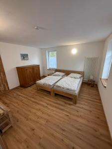 a bedroom with two beds and a wooden floor at Ferienwohnung Waidmannsheil in Amtsberg