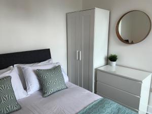 a bedroom with a bed with a mirror and a dresser at Consett Gorgeous Two Bedroom Apartment in Consett