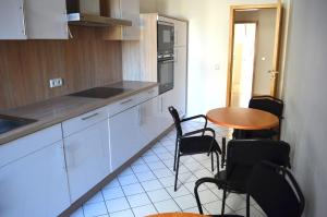 a kitchen with white cabinets and a table and chairs at Grosses Zimmer im Zentrum Elise , ruhig & gemuetlich in Chemnitz